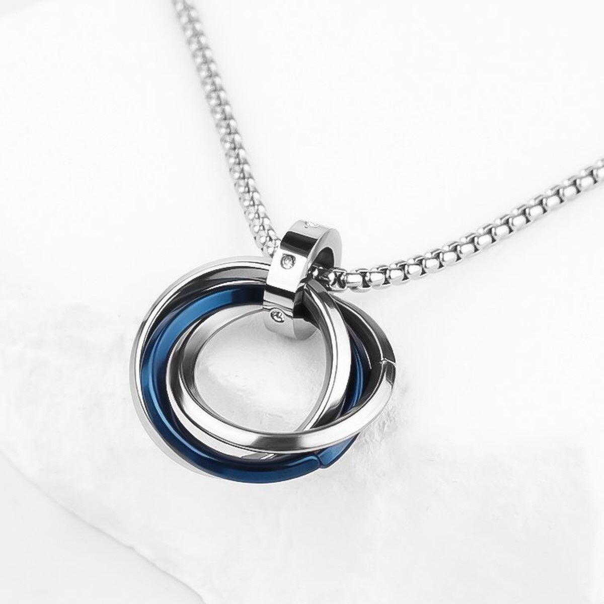 Close-up of Interlocking Ring Necklace showing overlapping silver-tone rings with blue accent detailing