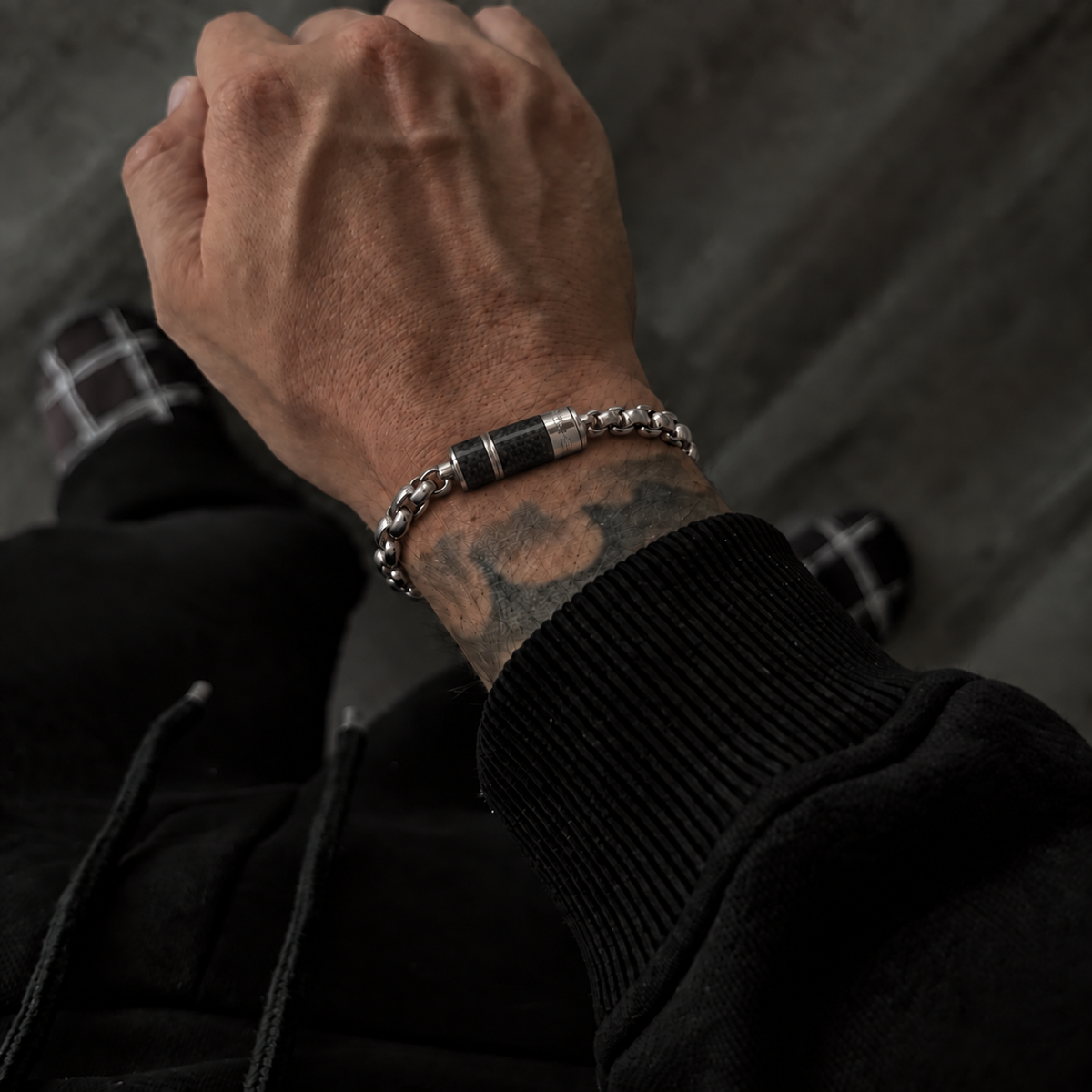 Men's Carbon Core Bracelet worn on wrist with a black outfit for a modern masculine look