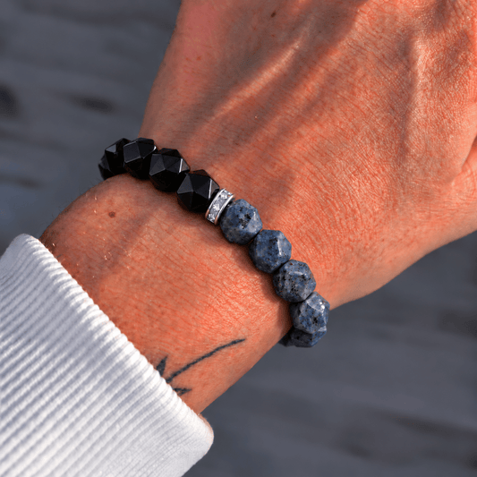 Poseidon Bracelet worn on wrist featuring black and blue-gray faceted beads