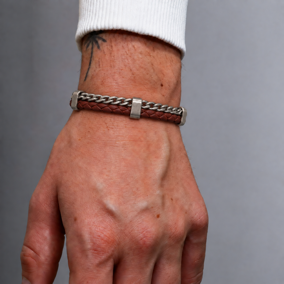 Close-up of men's Forge Leather Bracelet worn on wrist showing braided leather texture and metal details