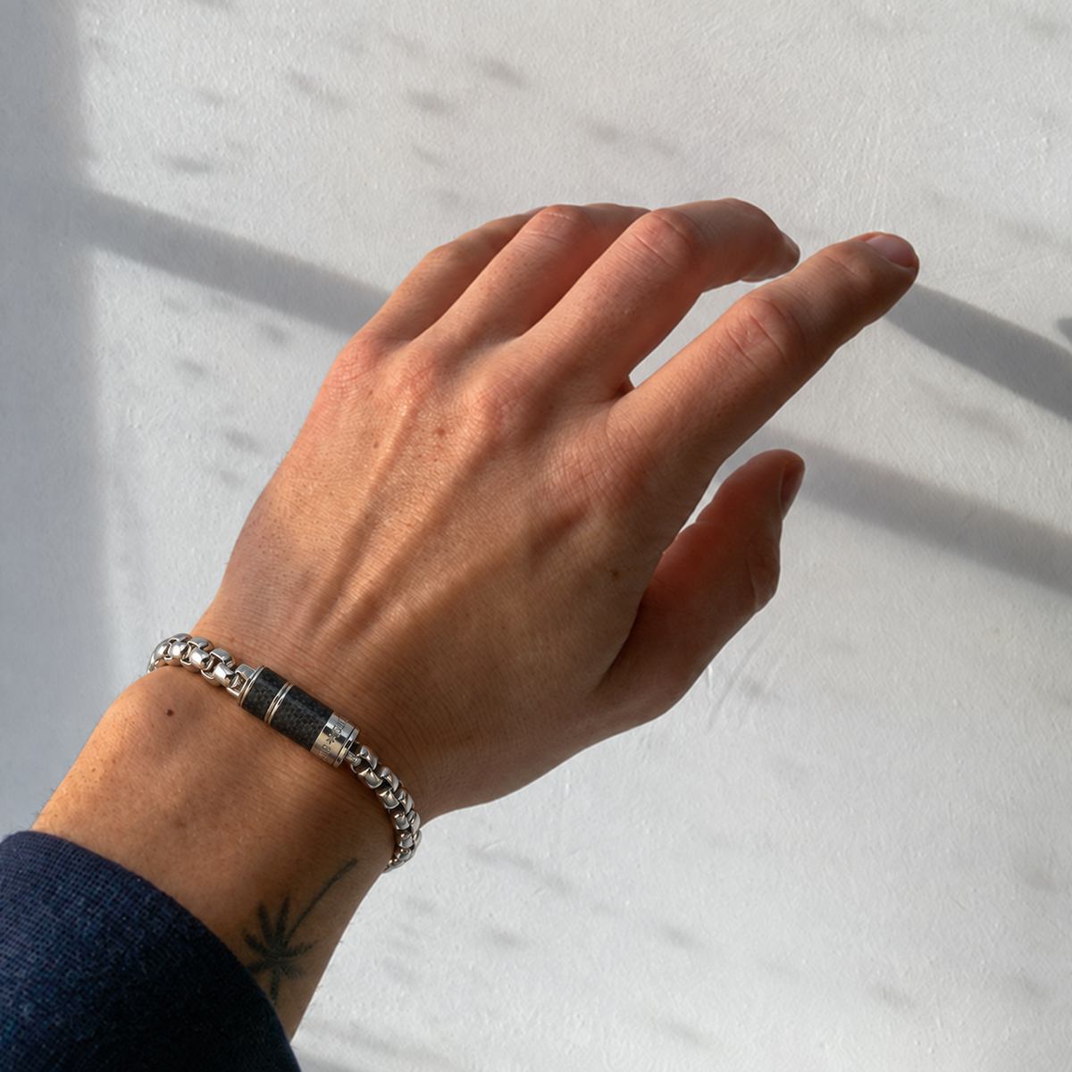 Men's Carbon Core Bracelet styled on wrist with a casual outfit featuring black and silver-tone accents