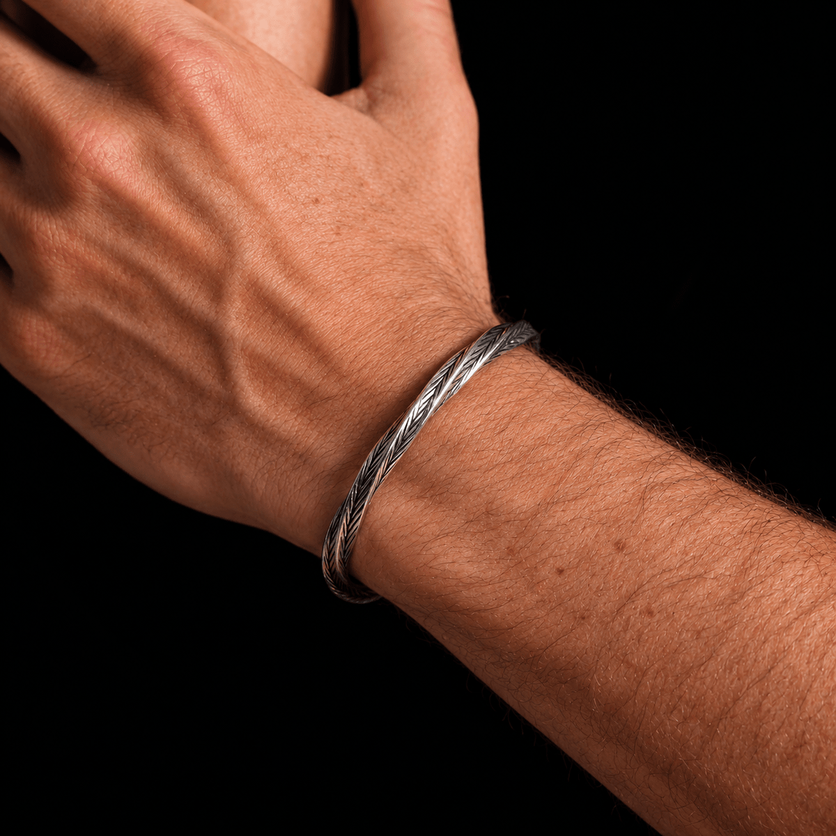 Aether Cuff men's open cuff bracelet styled on wrist with a black shirt for a modern casual look