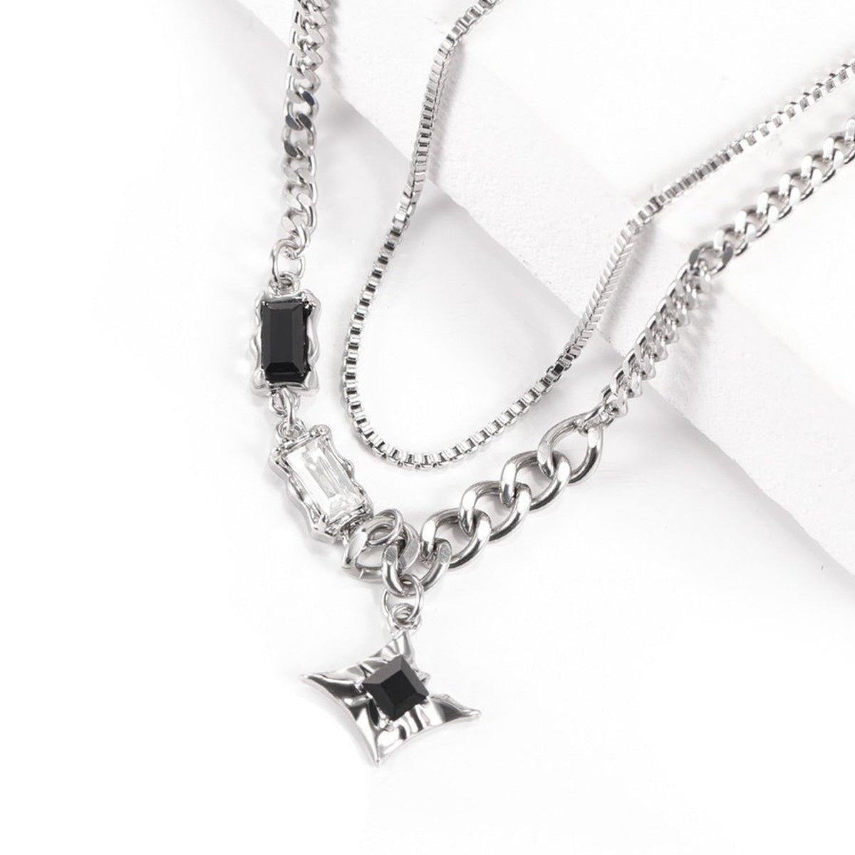 Close-up of Starburst Layered Necklace featuring layered silver-tone chains and a starburst pendant
