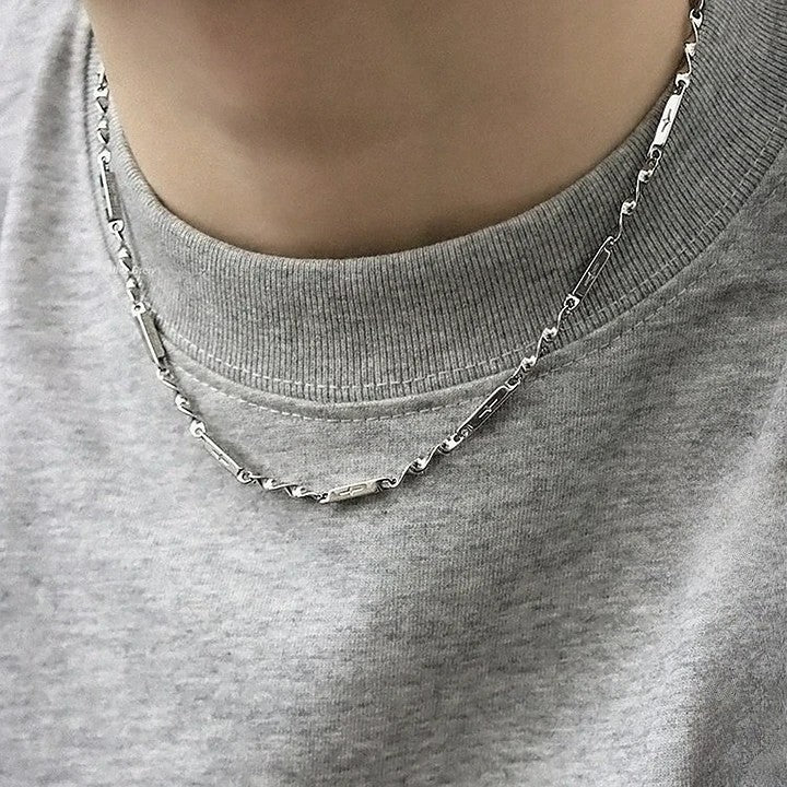 Men's Mobius Link Necklace worn with a gray T-shirt for a casual layered jewelry look